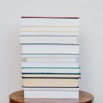 big pile of books on wooden stool